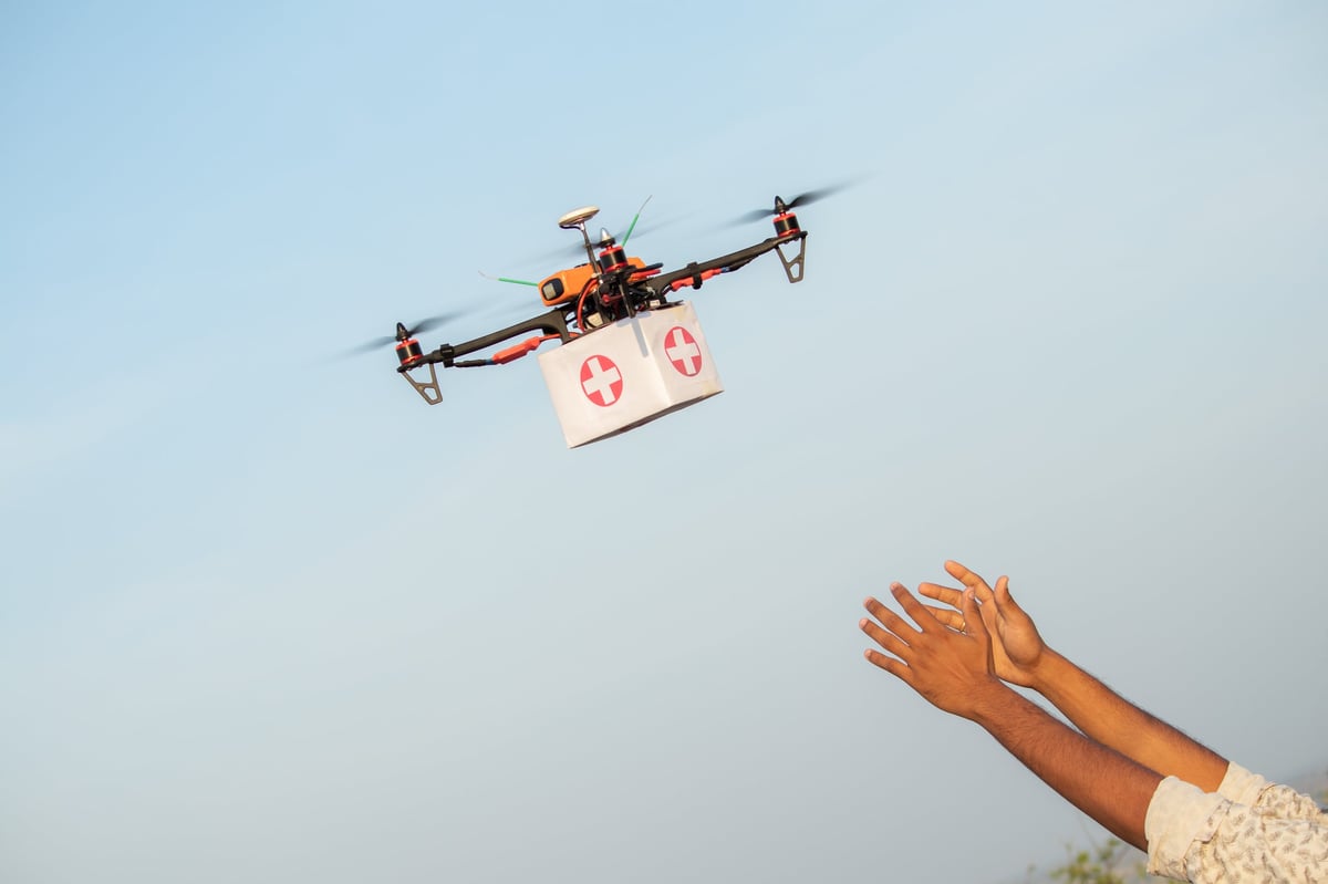 Drone delivering supplies to a person's hand